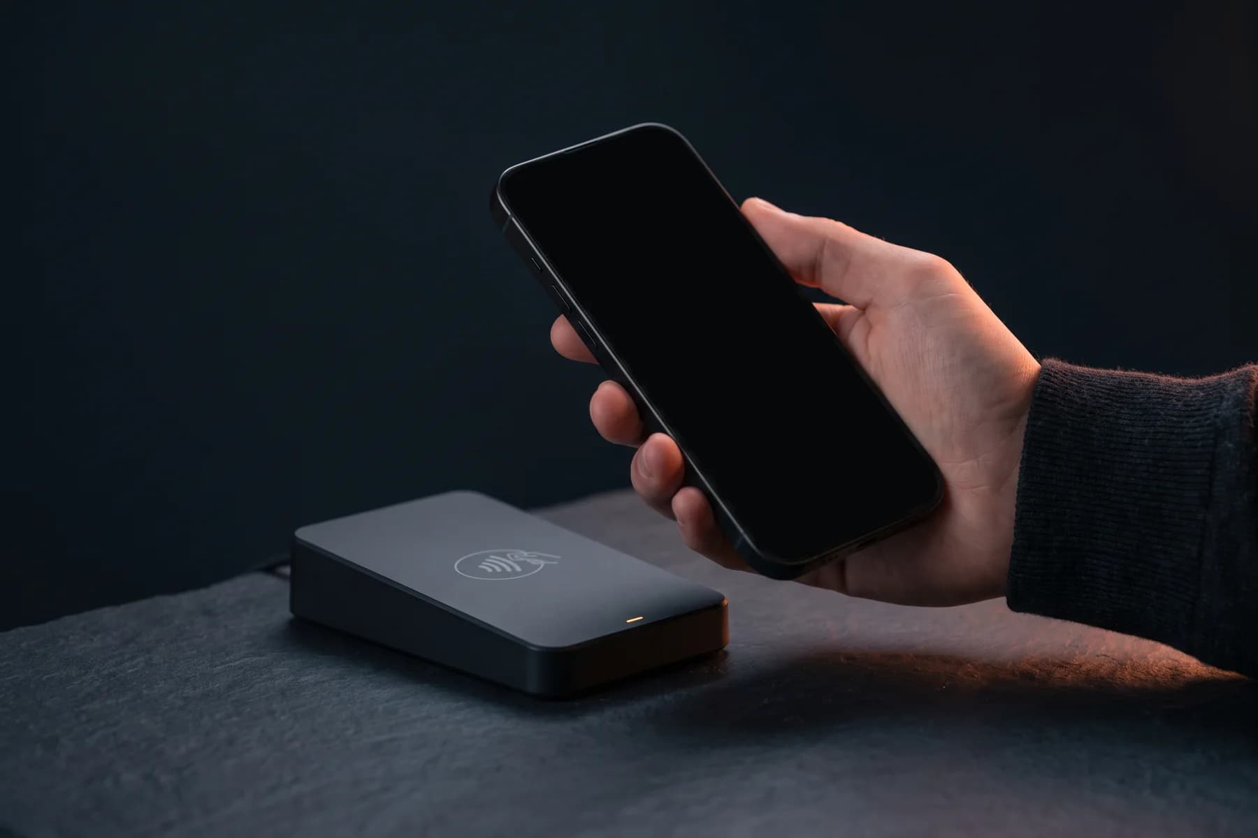 Desktop NFC reader verifying a wallet pass held on a phone